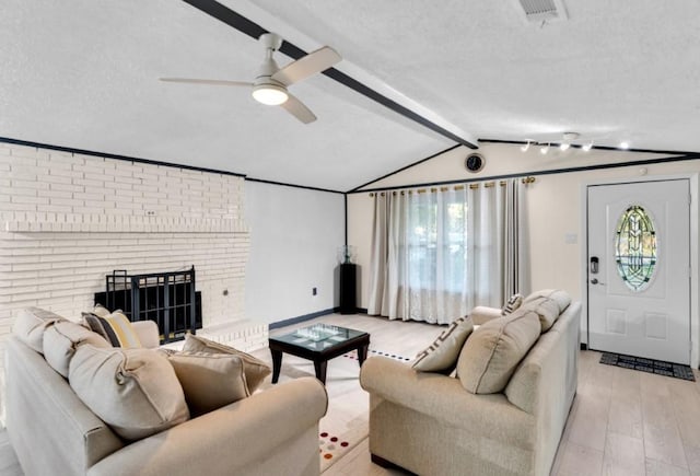 living room featuring a healthy amount of sunlight, ceiling fan, light hardwood / wood-style floors, and a textured ceiling