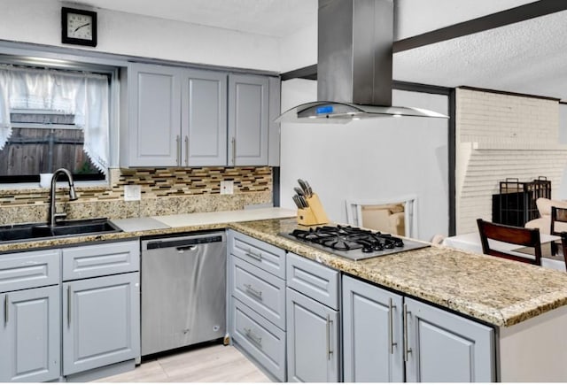 kitchen with wall chimney exhaust hood, gray cabinets, sink, and appliances with stainless steel finishes