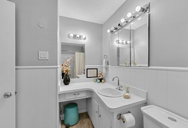 bathroom featuring vanity, curtained shower, toilet, and a textured ceiling