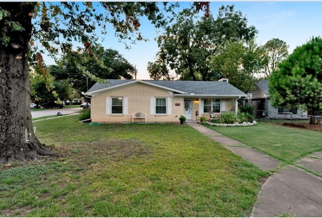 ranch-style home with covered porch and a front yard