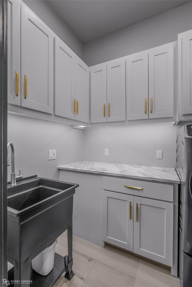 laundry area featuring cabinets, washer / clothes dryer, and sink