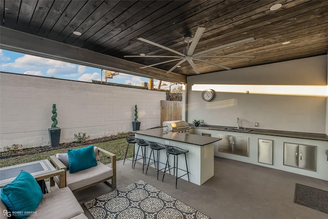 view of patio featuring area for grilling, an outdoor wet bar, ceiling fan, an outdoor living space, and exterior kitchen