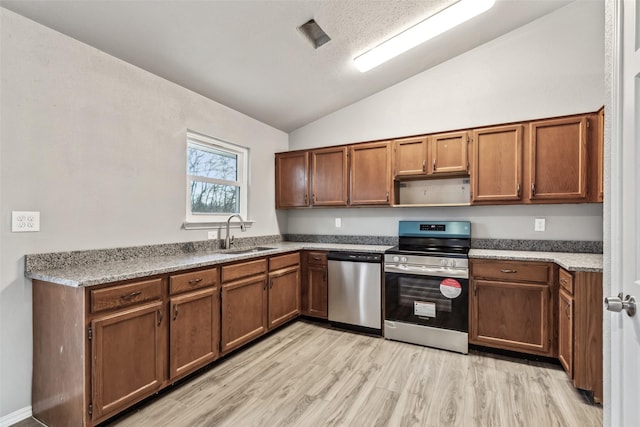 kitchen featuring sink, light hardwood / wood-style flooring, lofted ceiling, and appliances with stainless steel finishes