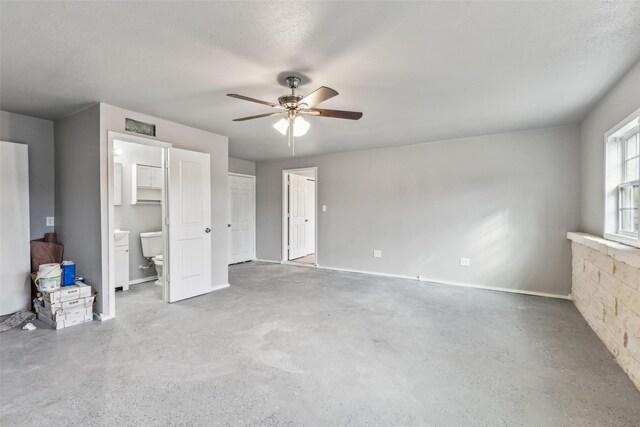 unfurnished bedroom featuring connected bathroom, ceiling fan, and concrete floors