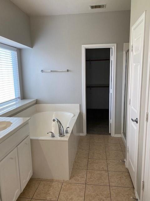 bathroom with tile patterned flooring, vanity, and separate shower and tub