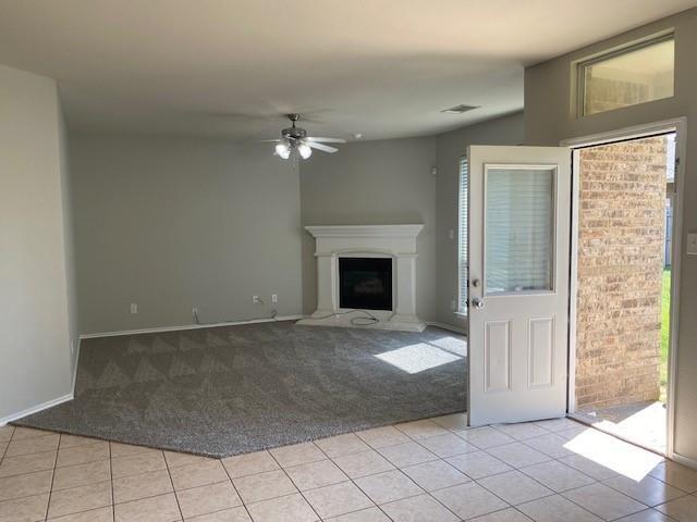 unfurnished living room with ceiling fan and light colored carpet