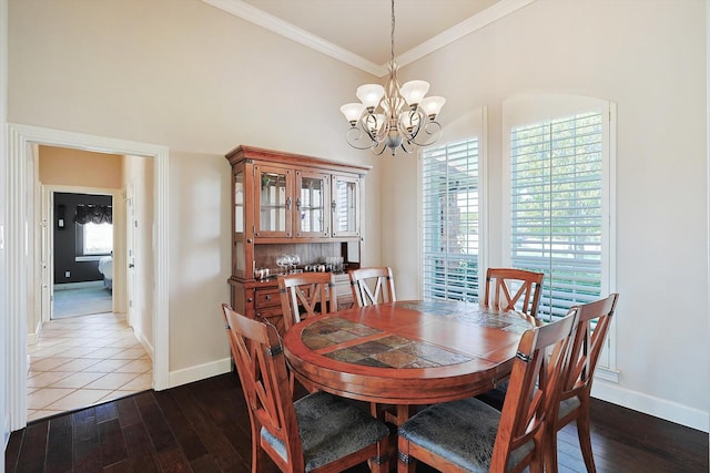 dining area featuring an inviting chandelier, ornamental molding, and dark hardwood / wood-style flooring