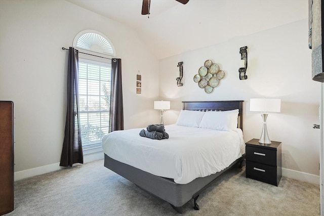 bedroom with vaulted ceiling, light colored carpet, and ceiling fan