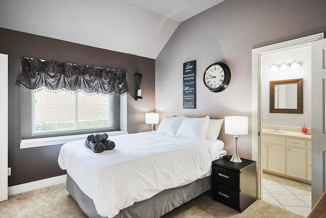 carpeted bedroom featuring lofted ceiling, sink, and ensuite bath