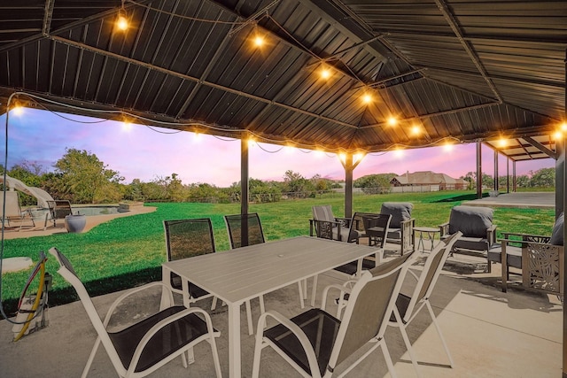 patio terrace at dusk with a gazebo and a lawn