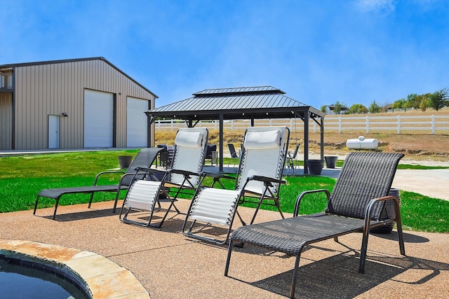 view of patio / terrace with an outbuilding, a garage, and a gazebo