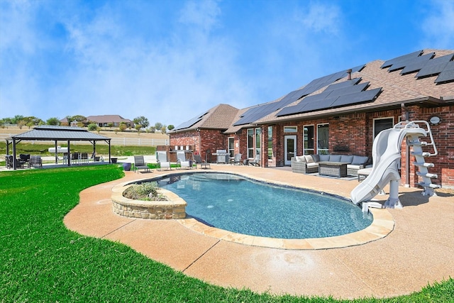 view of swimming pool featuring a lawn, an outdoor hangout area, a water slide, a gazebo, and a patio area