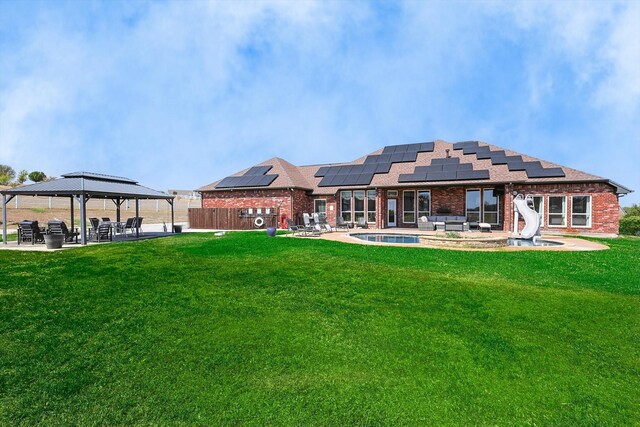 back of house featuring a yard, a gazebo, a patio area, and solar panels