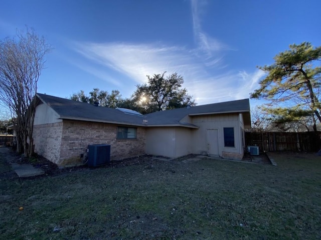 back of house with a lawn and central air condition unit