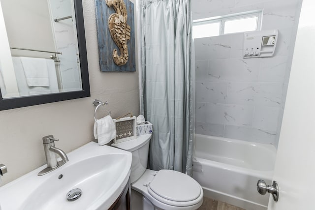 full bathroom featuring sink, shower / tub combo with curtain, and toilet