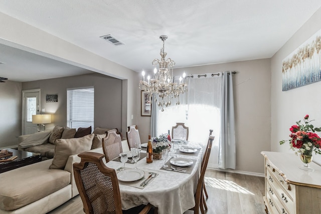 dining room with a chandelier and light hardwood / wood-style floors