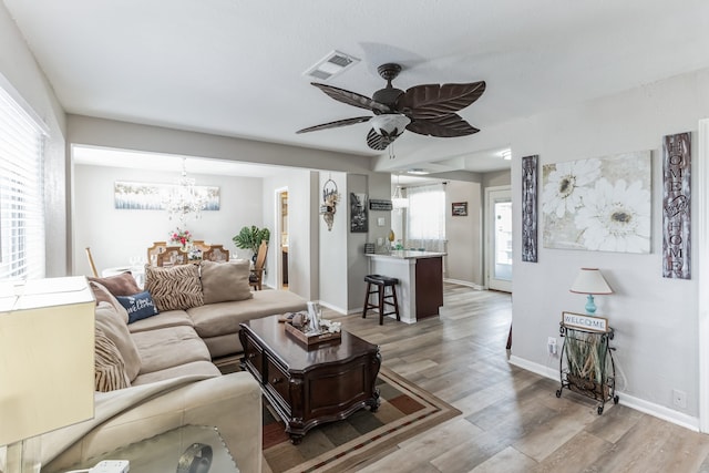 living room featuring plenty of natural light, light hardwood / wood-style floors, and ceiling fan with notable chandelier