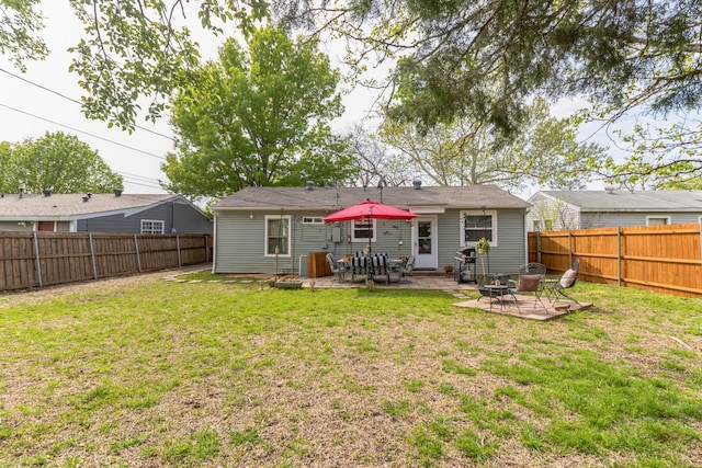 back of house featuring a lawn and a patio area