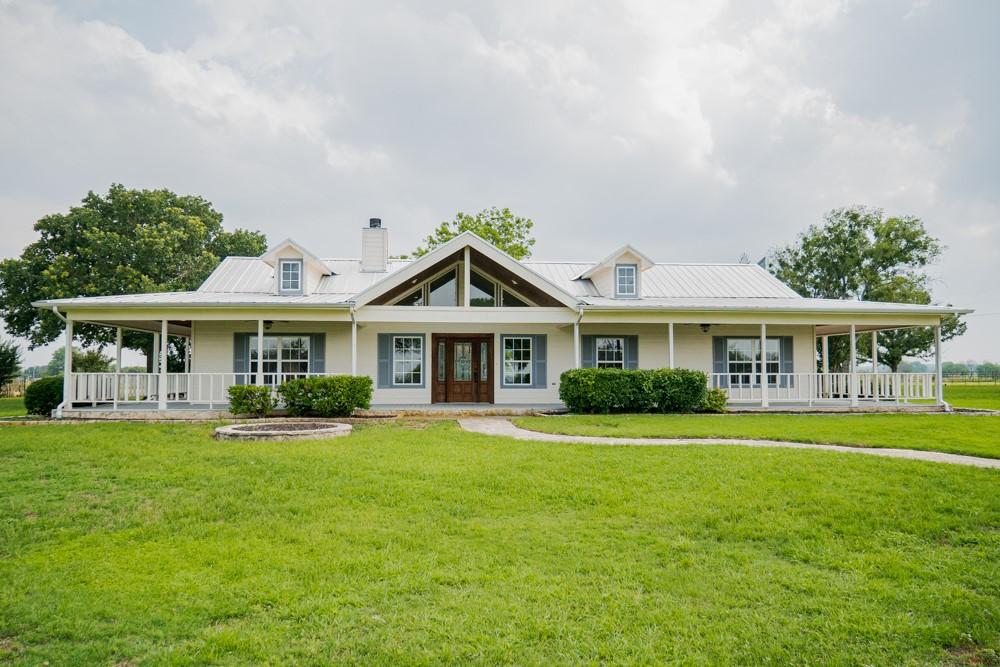 farmhouse with a porch and a front lawn