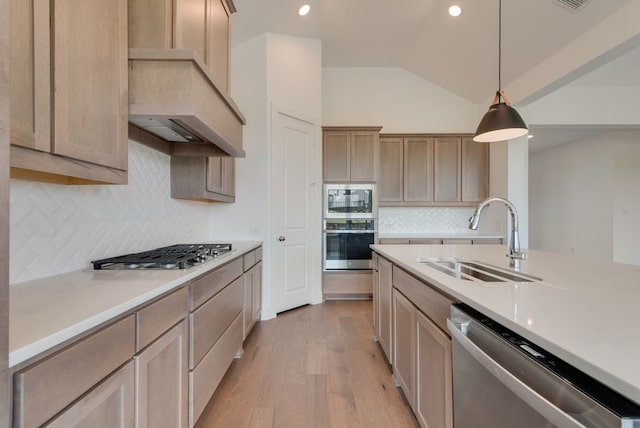 kitchen featuring custom exhaust hood, stainless steel appliances, sink, light brown cabinets, and hanging light fixtures