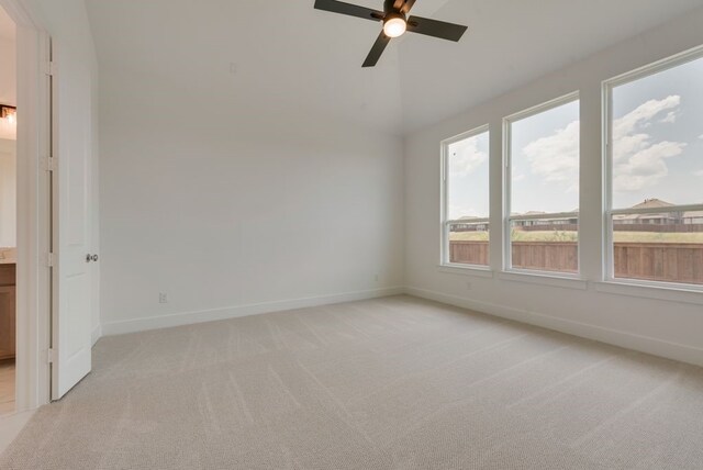 carpeted empty room with ceiling fan and vaulted ceiling