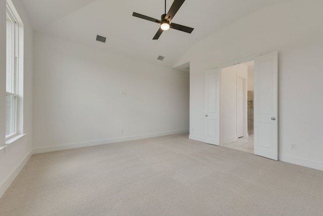 carpeted empty room featuring ceiling fan and vaulted ceiling