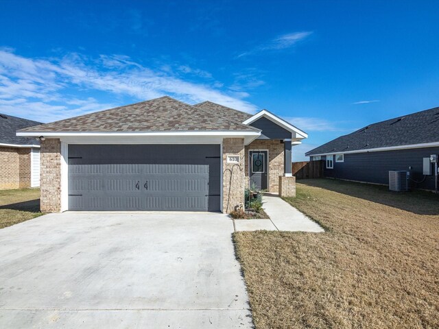 610 N Garrett Ave, Garrett, TX 75119 - ranch-style house with a front yard, central air condition unit, an attached garage, and driveway