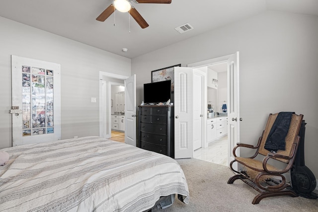 carpeted bedroom featuring lofted ceiling, ensuite bath, and ceiling fan