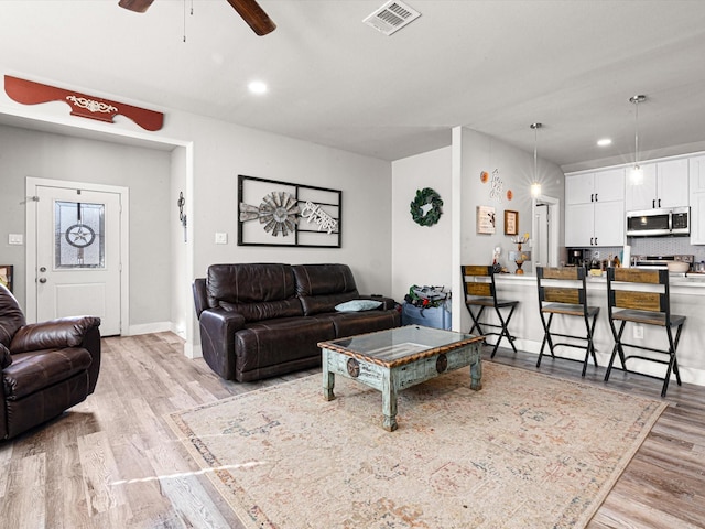 living room featuring light wood-type flooring and ceiling fan