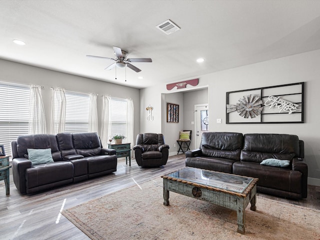 living room featuring ceiling fan, light hardwood / wood-style floors, and plenty of natural light