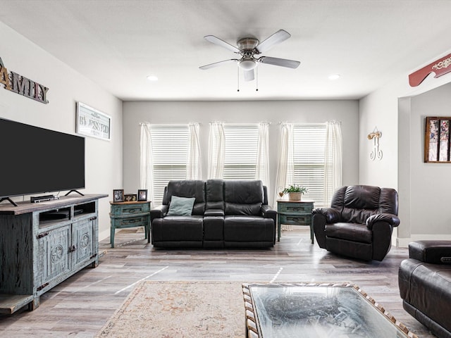 living room with light wood-type flooring and ceiling fan