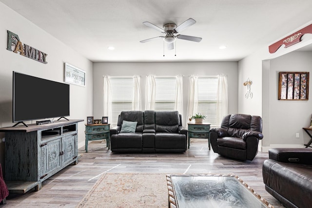 living room featuring plenty of natural light, ceiling fan, and light hardwood / wood-style flooring