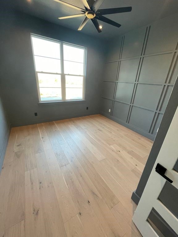 empty room featuring ceiling fan and light hardwood / wood-style floors