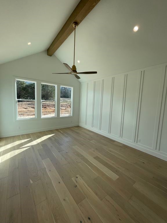 additional living space with ceiling fan, lofted ceiling with beams, and light wood-type flooring