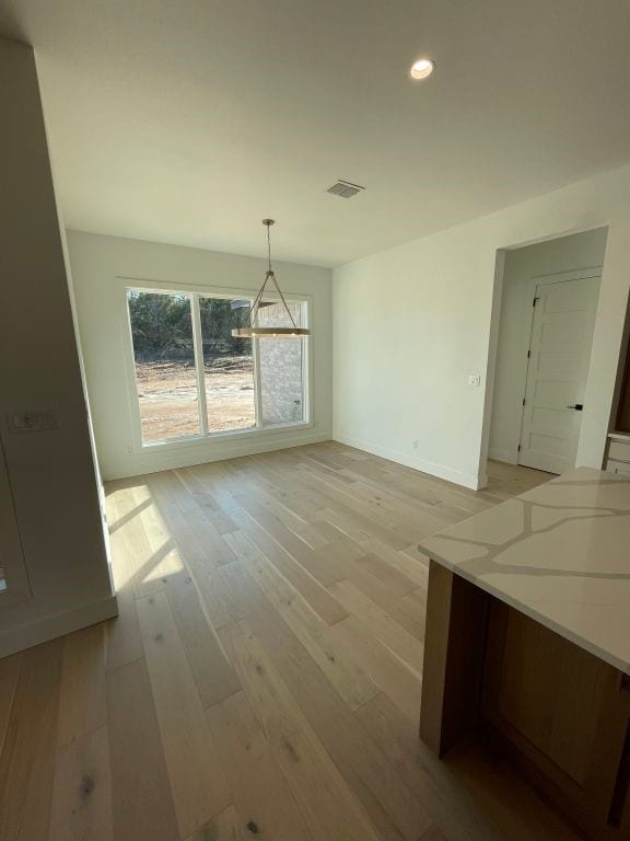 unfurnished dining area featuring light hardwood / wood-style flooring