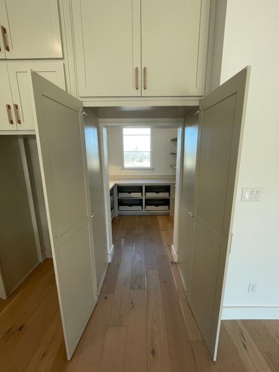 hallway with light hardwood / wood-style floors