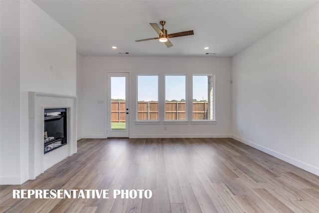 unfurnished living room featuring ceiling fan and light hardwood / wood-style floors