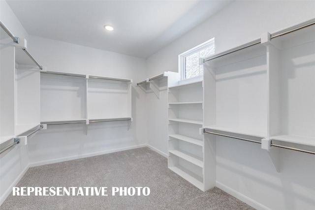 spacious closet featuring light carpet