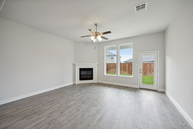 unfurnished living room with ceiling fan and light wood-type flooring