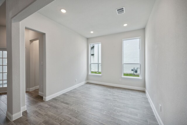 empty room featuring plenty of natural light and light hardwood / wood-style floors