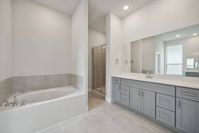 bathroom with tile patterned flooring, vanity, and plus walk in shower