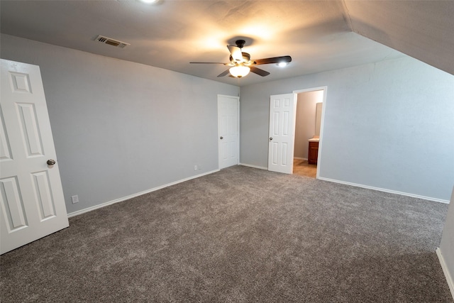 unfurnished bedroom with visible vents, connected bathroom, carpet, baseboards, and ceiling fan