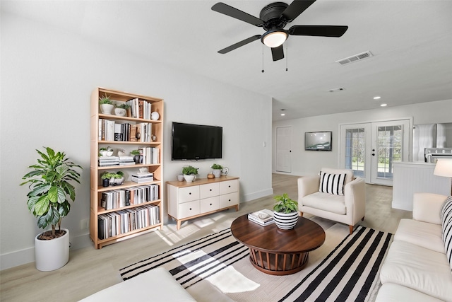 living room with ceiling fan, french doors, and light wood-type flooring