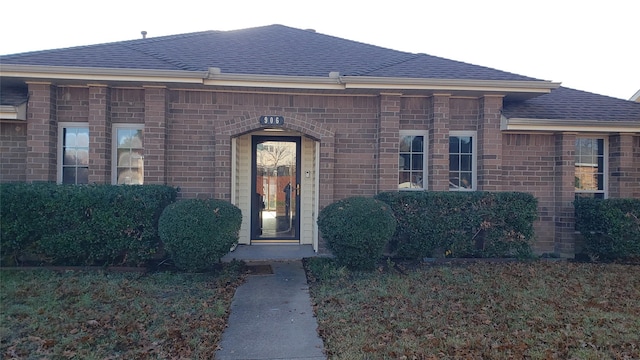 doorway to property with a lawn