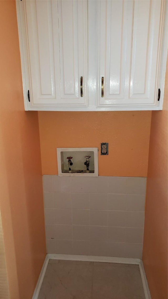 laundry room featuring hookup for a washing machine, tile patterned floors, and cabinets