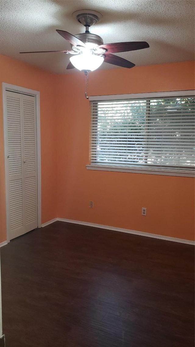 spare room featuring ceiling fan, dark hardwood / wood-style floors, and a textured ceiling