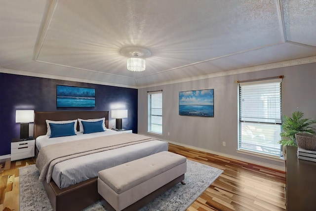 bedroom featuring light hardwood / wood-style flooring, a chandelier, and ornamental molding