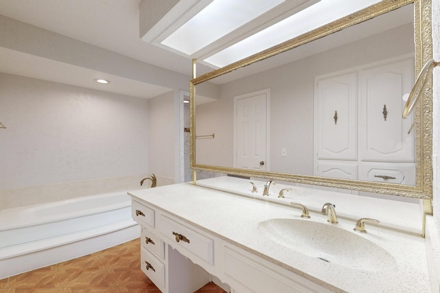 bathroom featuring vanity, parquet floors, and a tub