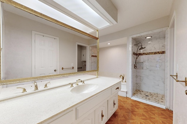 bathroom with vanity, parquet flooring, and tiled shower