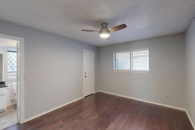 spare room with ceiling fan, dark hardwood / wood-style flooring, and a textured ceiling